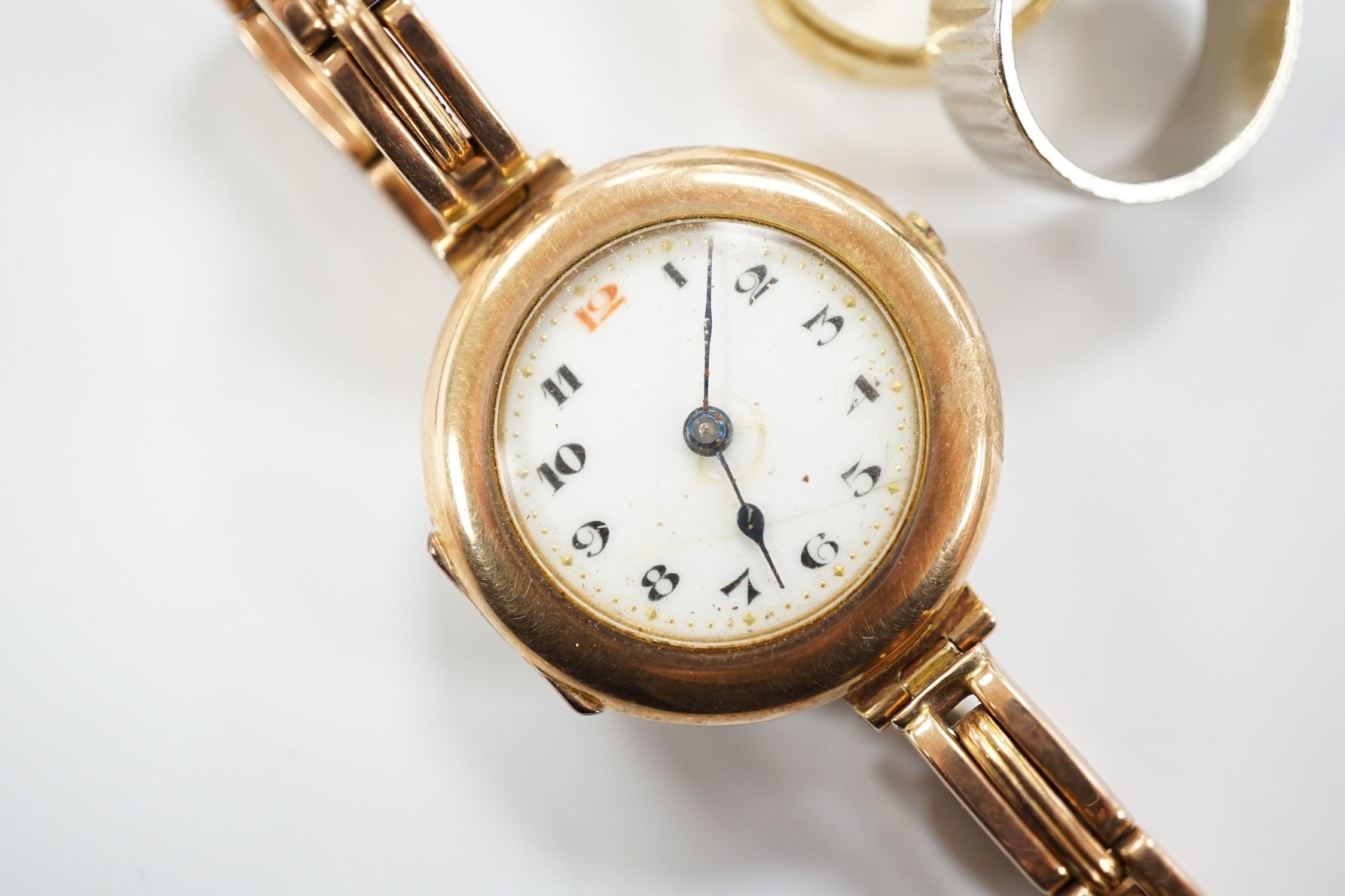 A textured white metal (stamped platinum) band, 7 grams, an 18ct gold band,4.5 grams and a 9ct gold manual wind wrist watch, on a 9ct expanding bracelet, gross weight 23 grams.